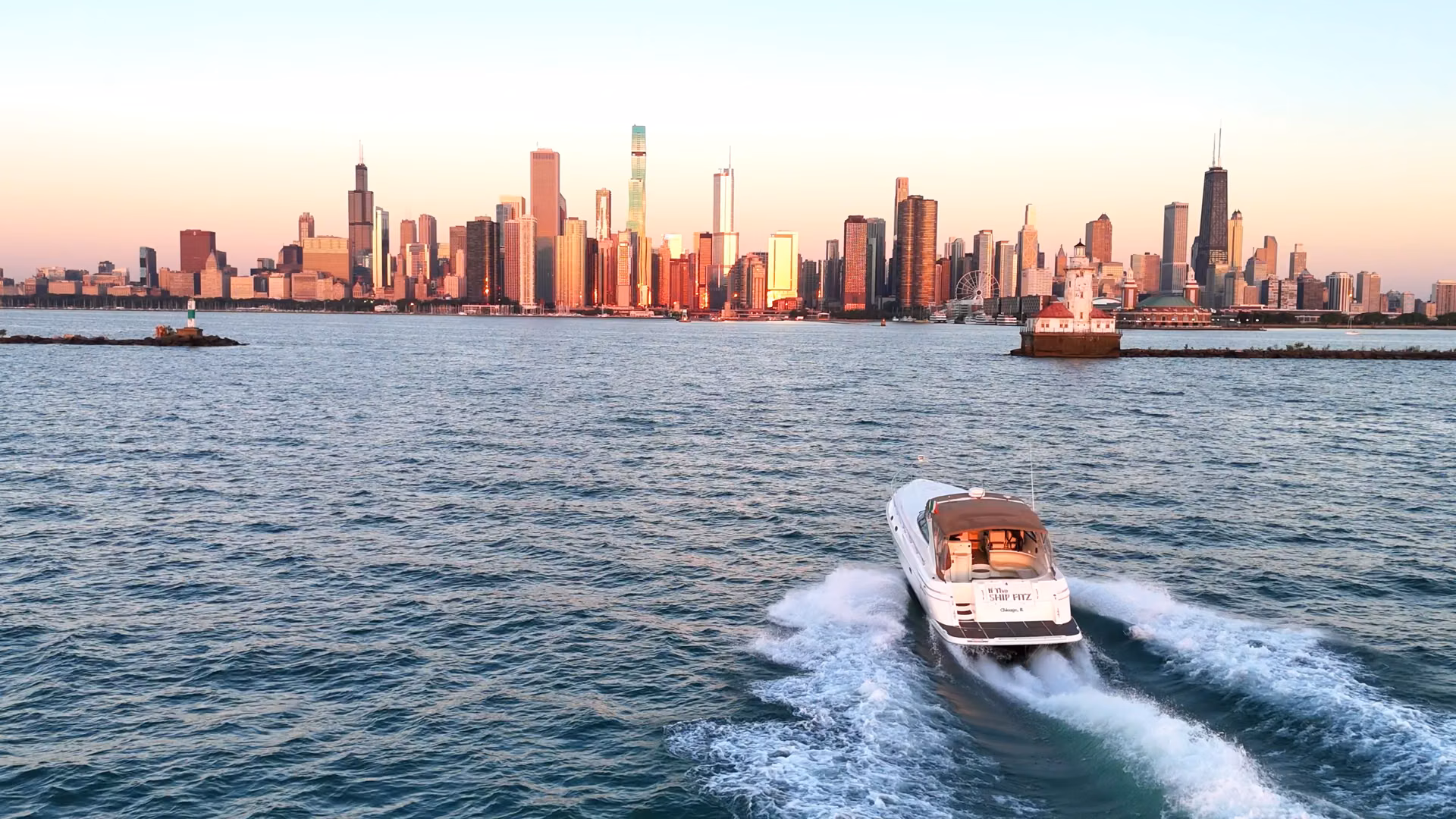 Boat cruising near city skyline at sunset