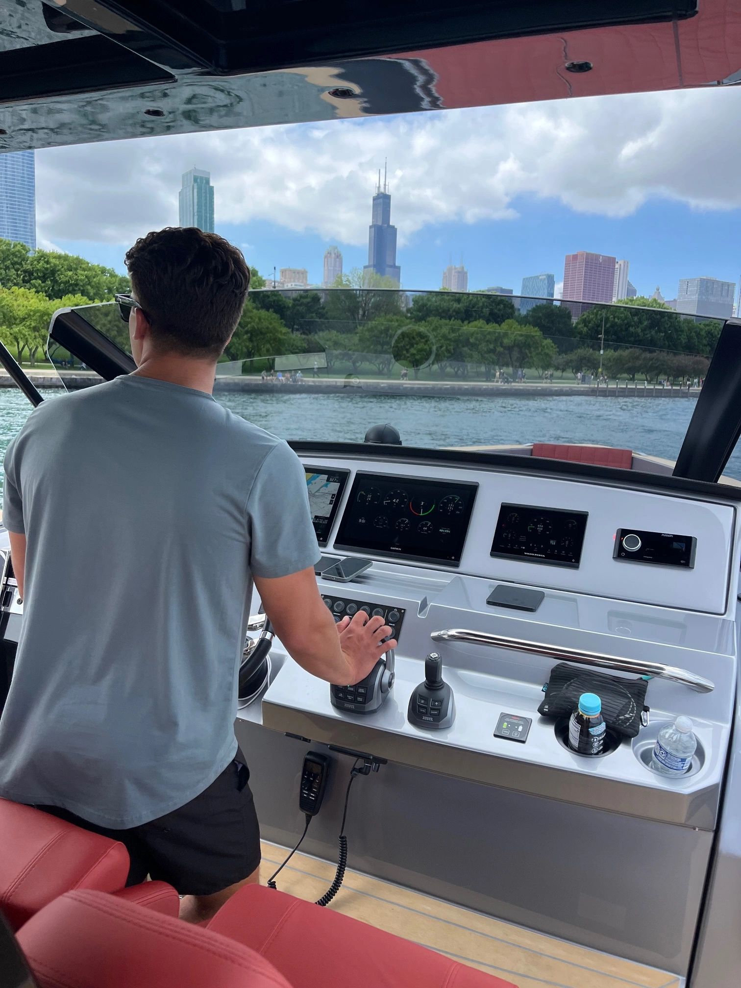 Man piloting yacht near cityscape