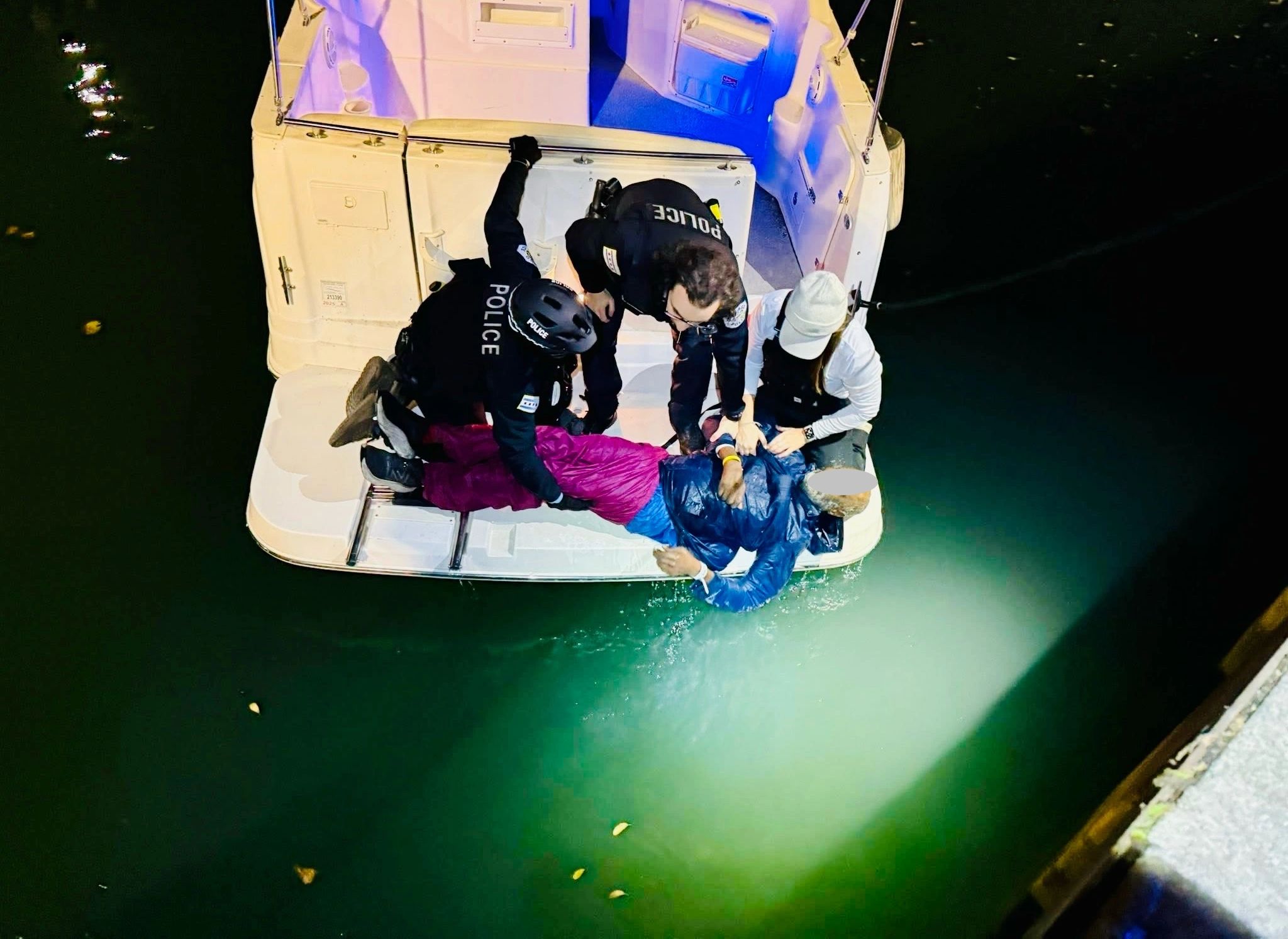 Police officers rescuing person from water