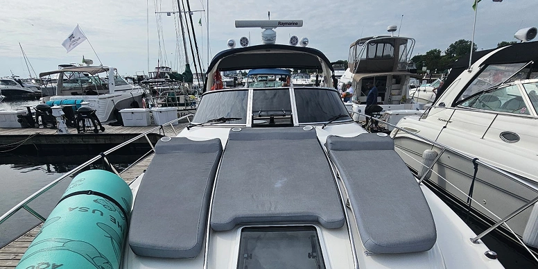 Group of boats docked at a marina with a wooden bridge in the background