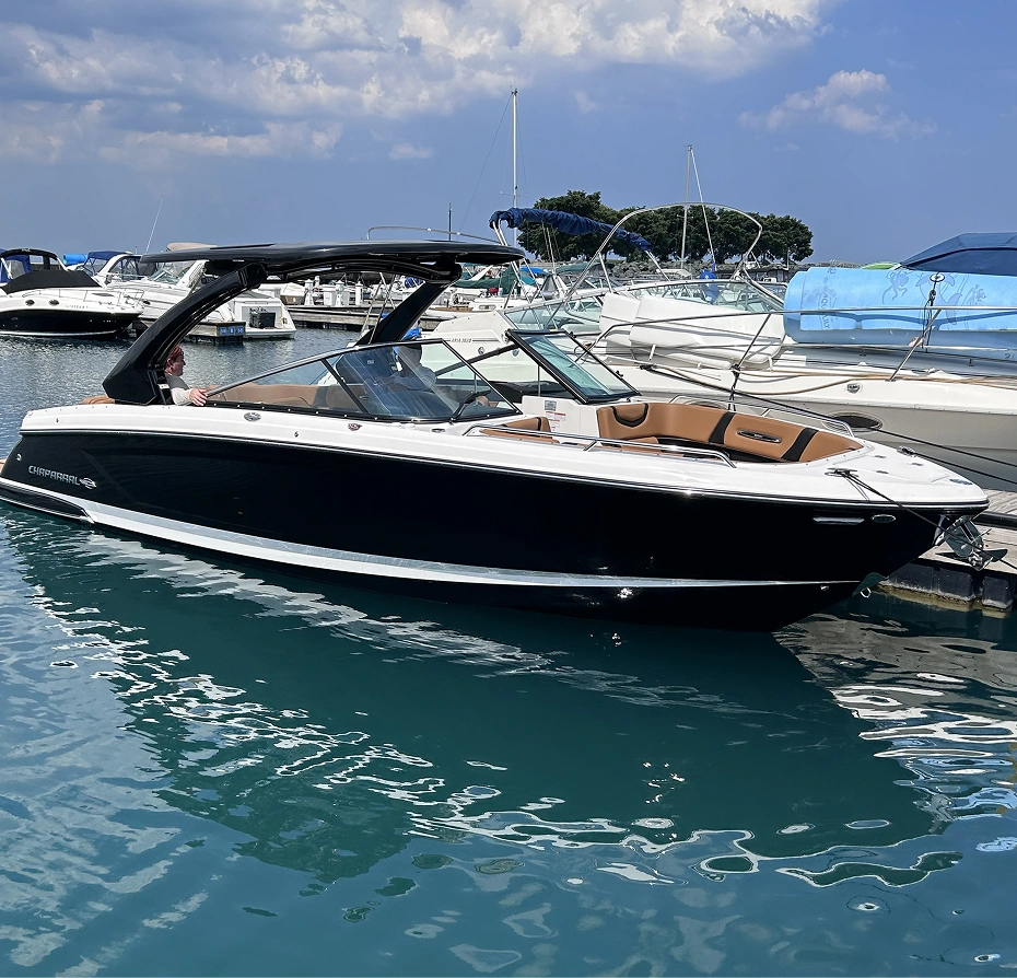 Black and white boat docked at a marina with other boats in the background