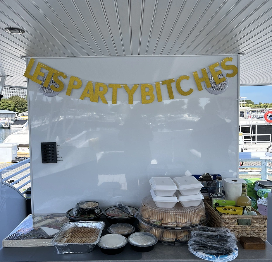 Table with food items in trays, boxes, bottles, baskets and other objects on it