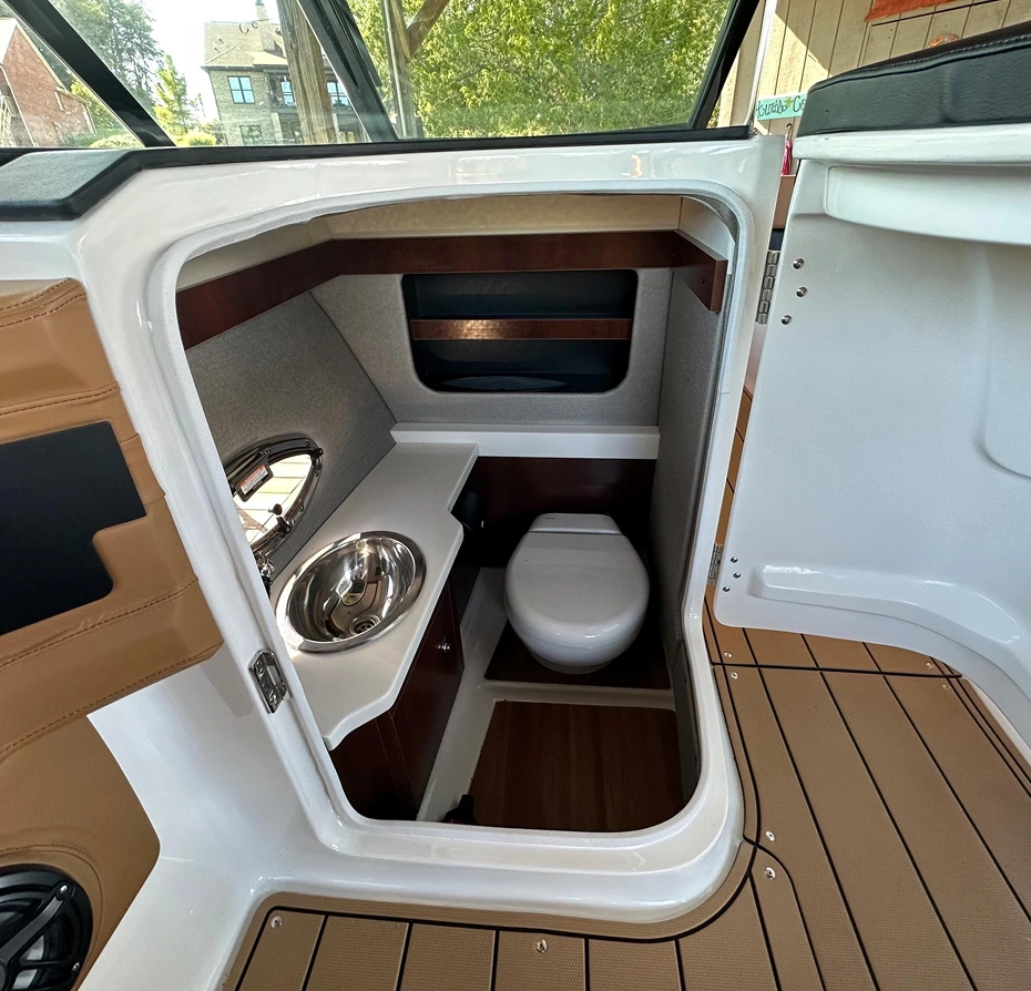 White and brown boat with a toilet in the middle of it