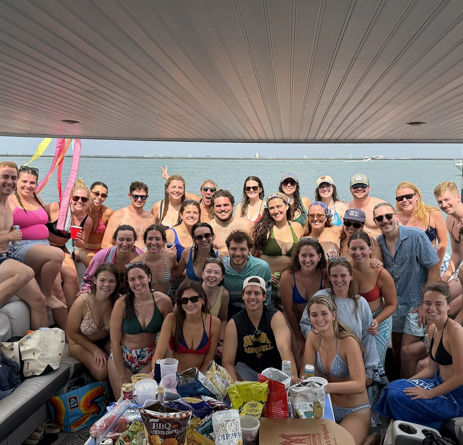 Group of people sitting on top of a boat, and enjoying a picnic