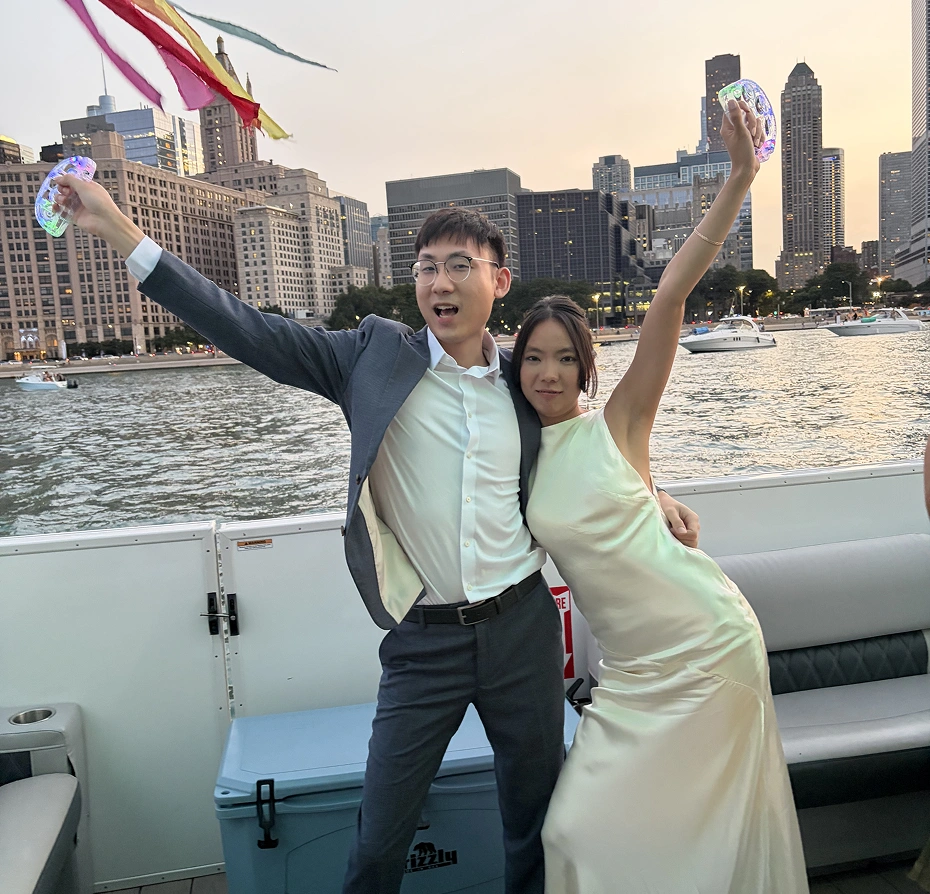 Man and woman standing on top of a boat, holding up a kite