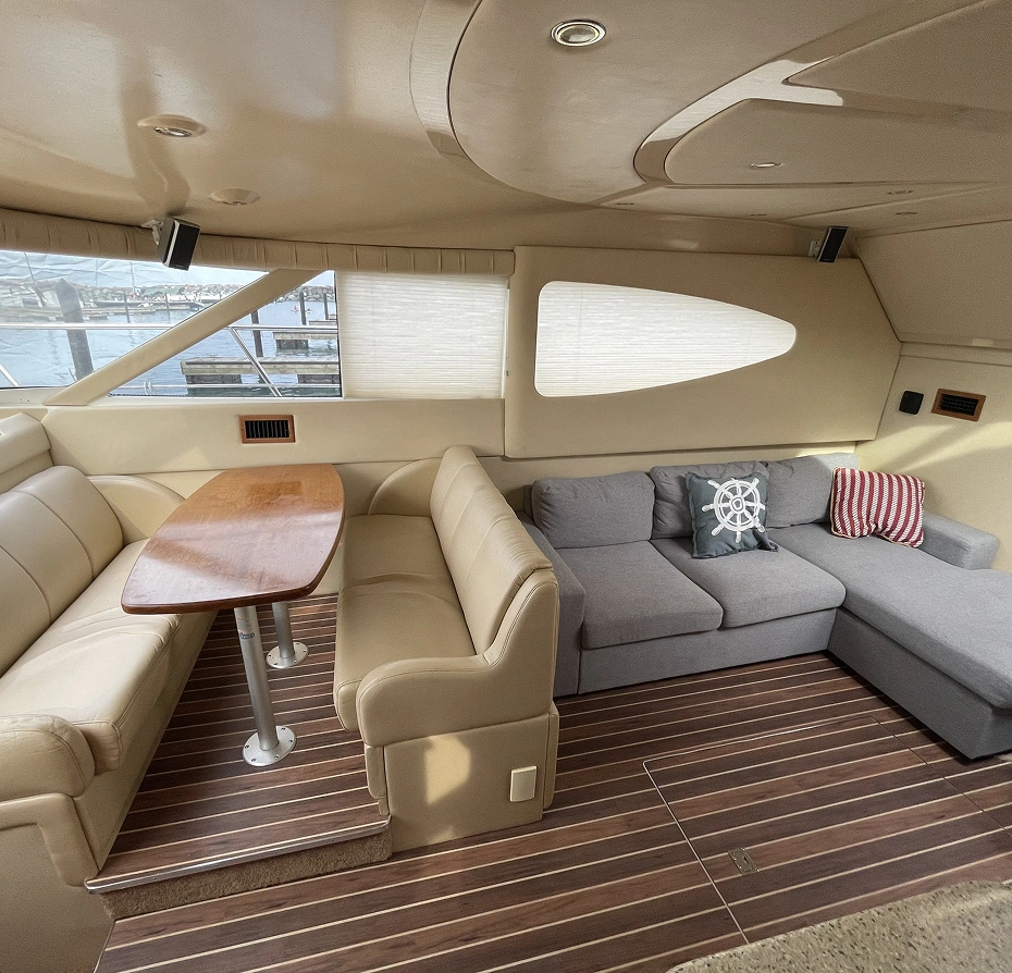 Living room with a sofa set, pillows, a table, a carpet on the floor, windows