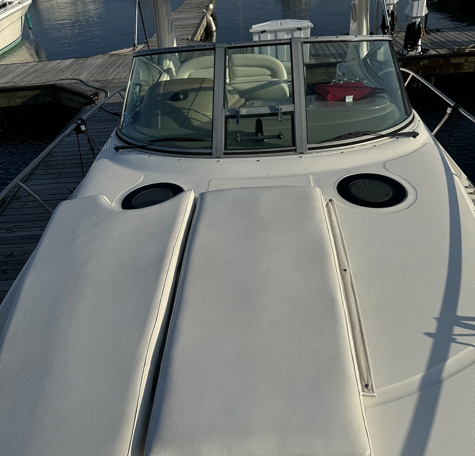 White boat docked at a dock with other boats in the background