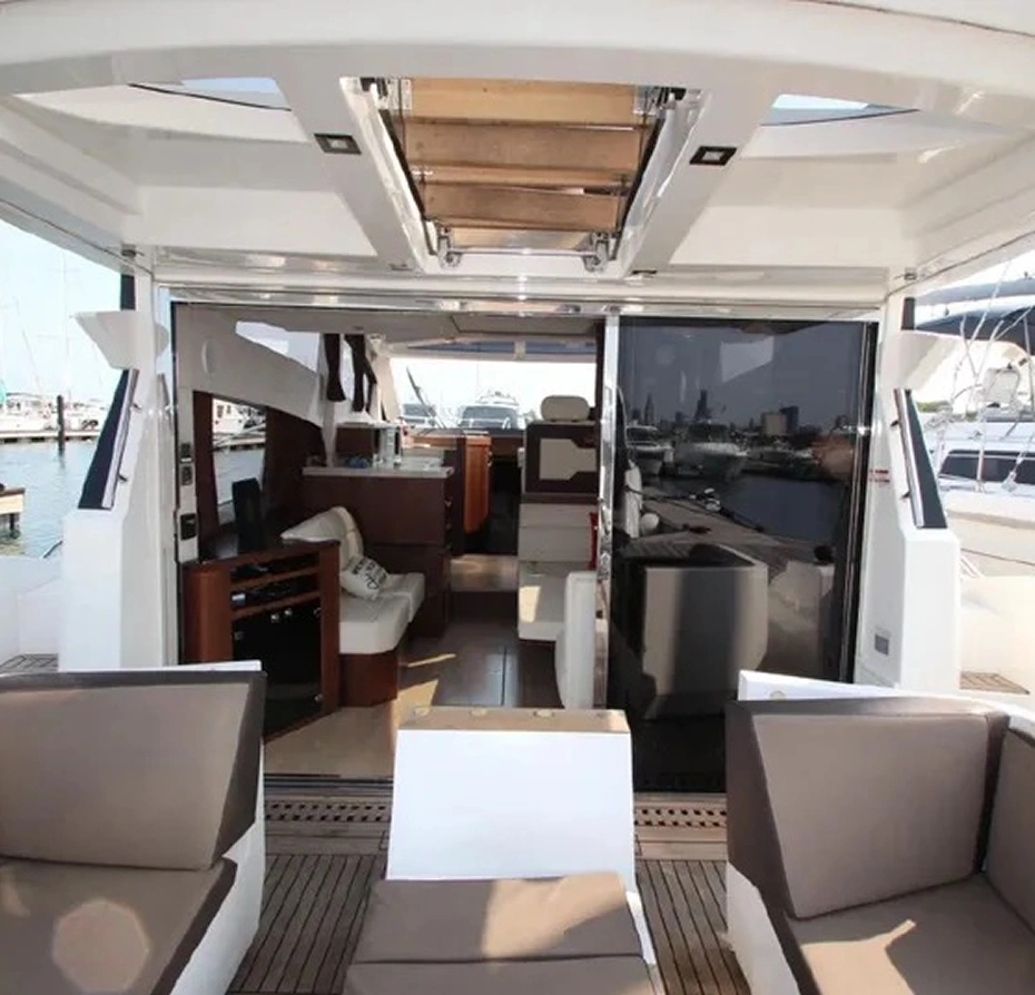 Interior of a boat with a couch and a table on it, surrounded by sofas, tables, and other objects