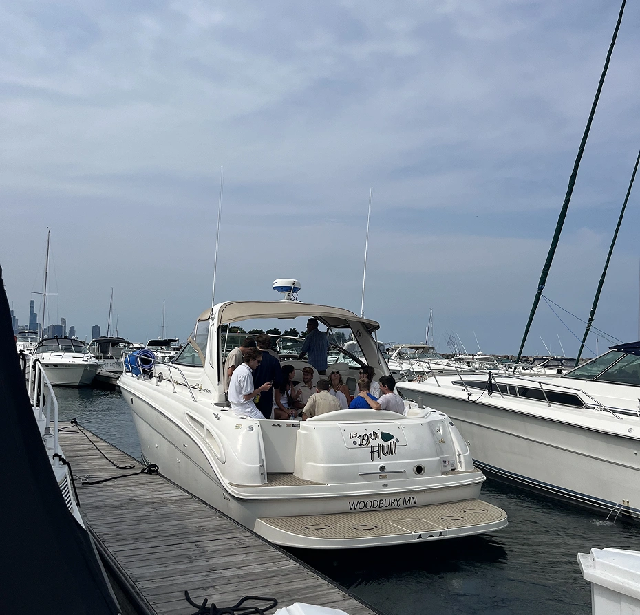 Group of people on a boat docked at a dock, surrounded by other boats on the water