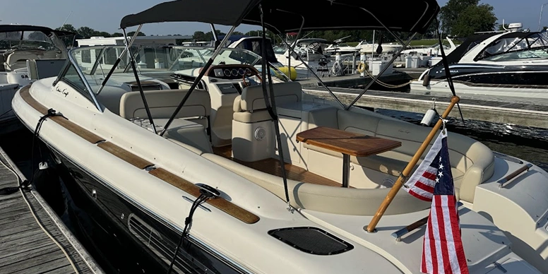 270 Sundancer boat docked at a dock with an American flag on it, surrounded by other boats on the water