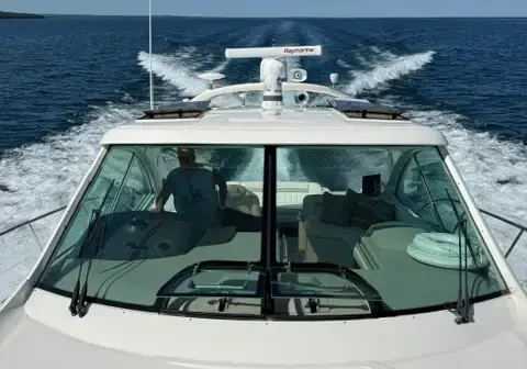 Man riding on the back of a white boat, the 510 Sundancer, on the water