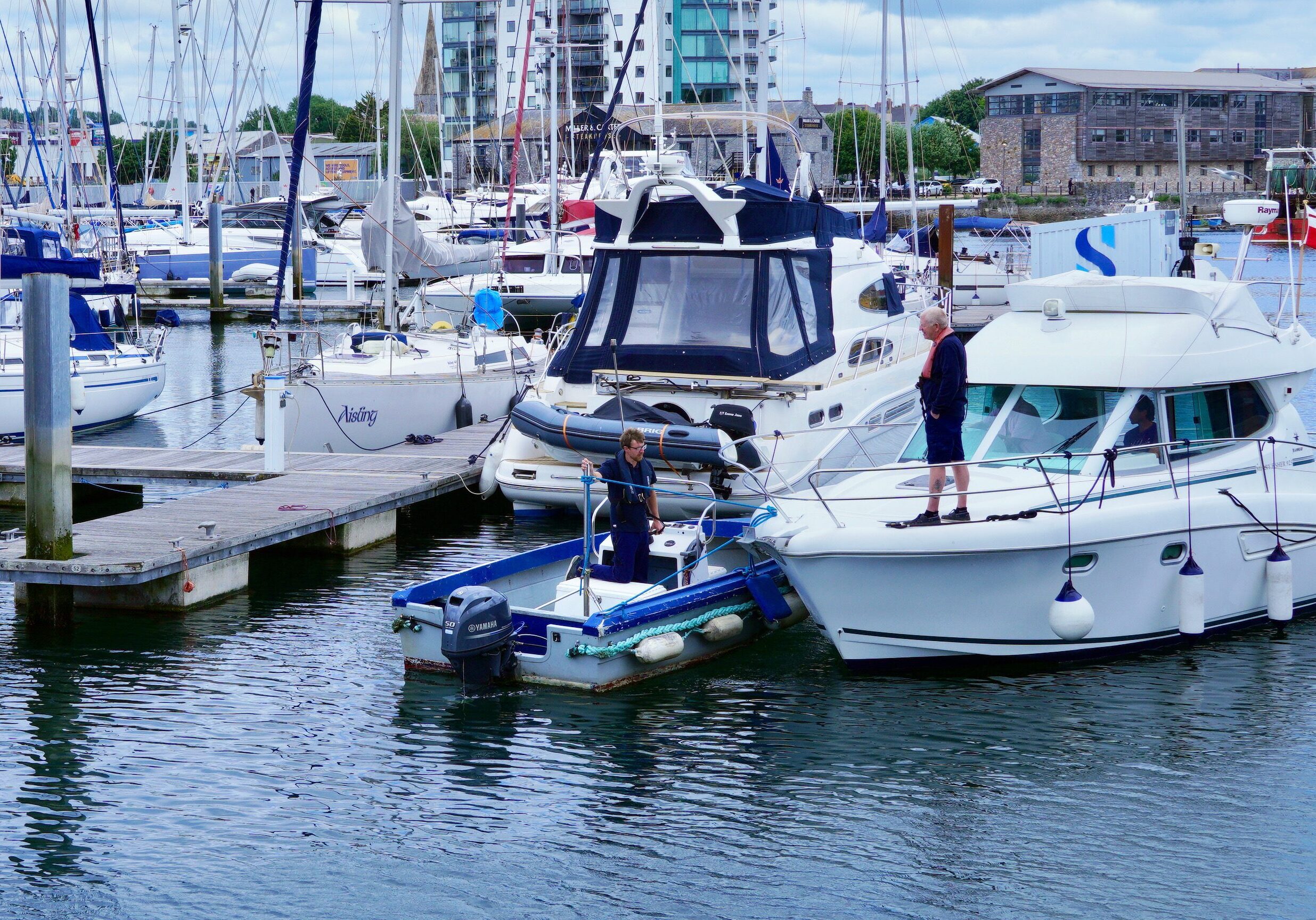Marina scene with docked boats and people