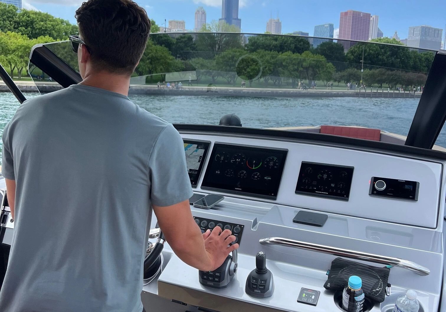 Man piloting yacht near cityscape