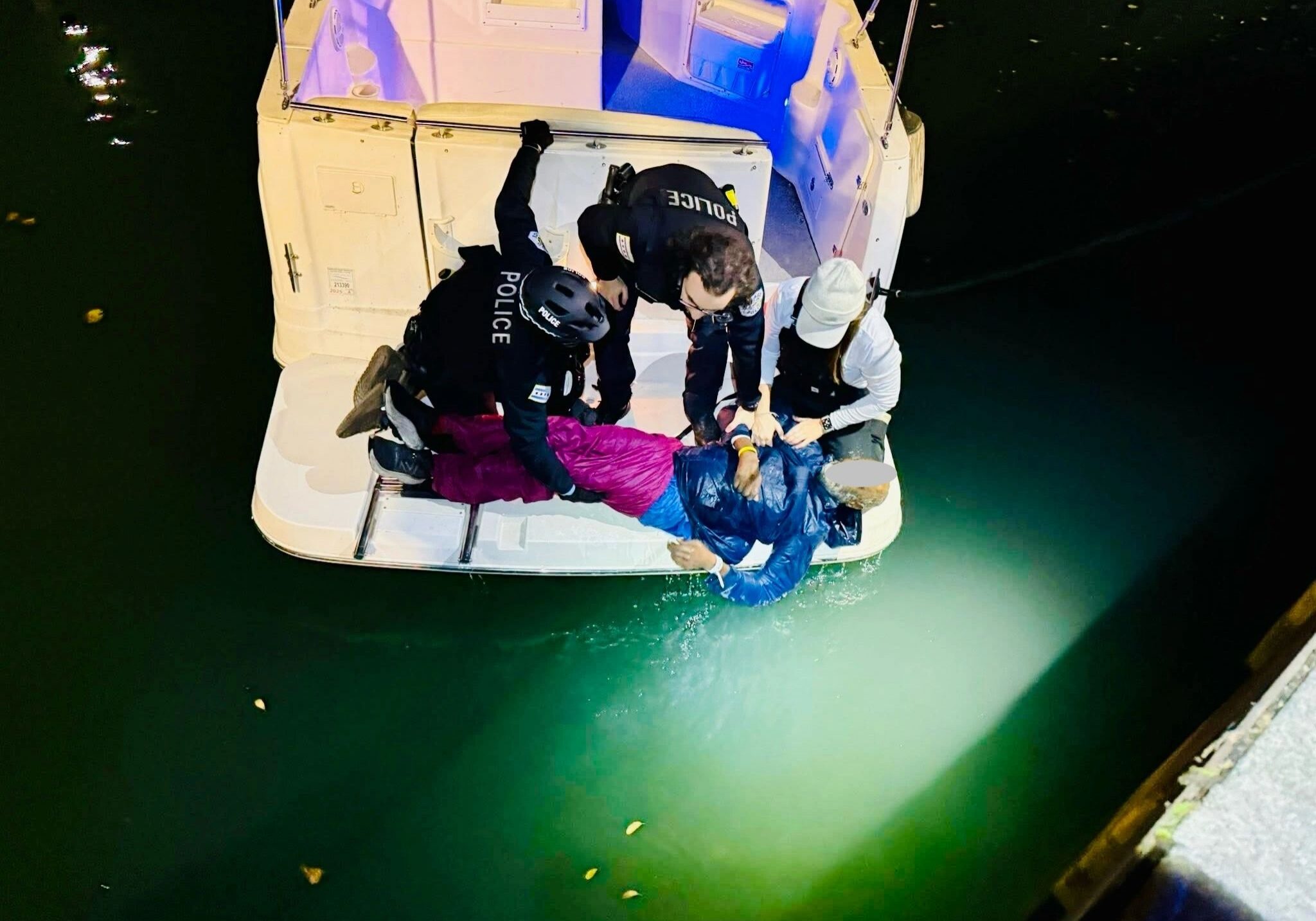 Police officers rescuing person from water