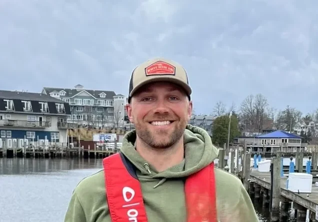 Man smiling by a marina