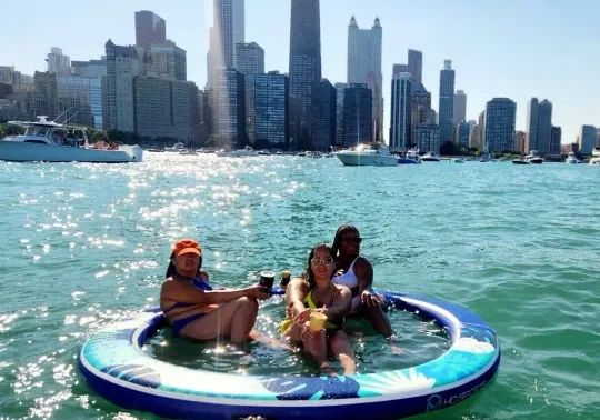 Friends on a circular inflatable with the Chicago skyline behind them